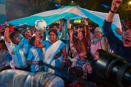 Fans react after Argentina scores a goal during a FIFA World Cup Qatar 2022 final match between Argentina and France on a big screen at Kolkata.