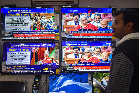 A man seen watching Finance Minister of India Nirmala Sitharam announce the Union Budget at Parliament on TV.