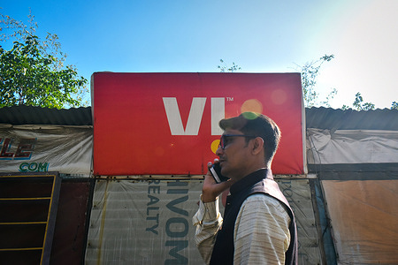 A person talking on his mobile in front of a Vodafone retail store on the outskirts of Kolkata. The government has agreed to convert Vodafone Idea’s accrued interest worth over Rs 16,000 crore on deferred adjusted gross revenue (AGR) dues into equity at Rs 10 a share. The move came after the government received an assurance from the promoters of the carrier that they are committed to the company and will bring in the necessary funds.