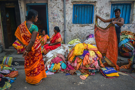 A person assembled old sarees in a second-hand saree market.