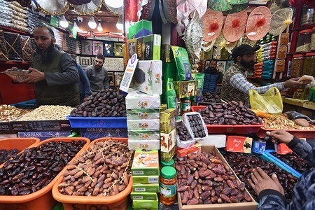 A shopkeeper selling dates waits for customers at a market in Srinagar, as people buy food items to break the fast during the Muslim holy fasting month of Ramadan..