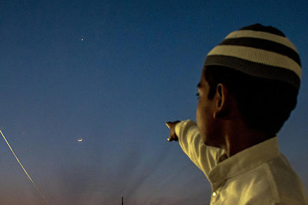 A boy points at the crescent moon as it marks the beginning of the holy month of Ramadan. According to the Islamic calendar, Ramadan marks the most auspicious month of Islam across the world. It is considered the ninth month of the Islamic calendar and occurs at the end of the Shaban month.