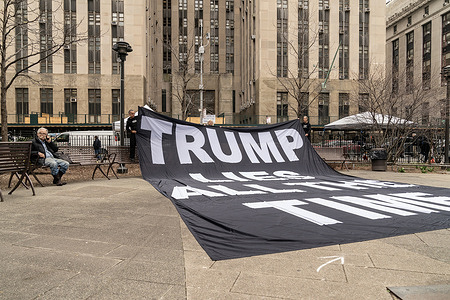 A handful of protesters outside of the Manhattan Criminal Court unveiled a huge banner against former President Trump as the grand jury continues deliberation.