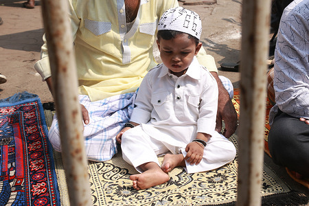 A boy offers first Friday prayer of the holy month of Ramadan on the street.