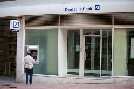Oviedo, SPAIN: A man withdraws money at the Deutsche Bank ATM during the very nervous drag of European banks again, with falls of more than 8% for Deutsche Bank on March 24, 2023, in Oviedo, Spain Spain.