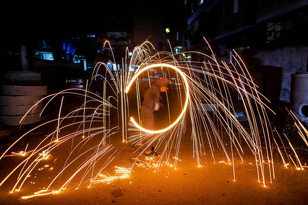 Palestinian youth swirl homemade sparkler fireworks made of steel wire wool as people celebrate the Muslim holy month of Ramadan in Gaza Strip.