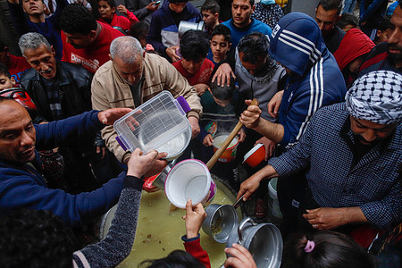 Palestinian Walid Al-Hattab distributes soup for the needy during the Muslim's holy fasting month of Ramadan in Al-Shujaia neighborhood East of Gaza City.