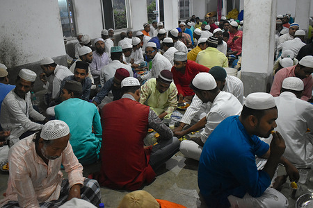 Muslims eat their Iftar (breaking fast) meal inside a mosque during the holy fasting month of Ramadan on the outskirts of Kolkata.