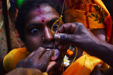 A devotee takes part in a Hindu religious procession to mark the Panguni Uthiram festival in New Delhi. 

Tamilians living in south Delhi gather at various temples to celebrate ‘Panguni Uthiram’, a festival dedicated to Lord Karthik, by piercing their faces and tongues with sharp objects and hooks in their backs to pull vehicles.