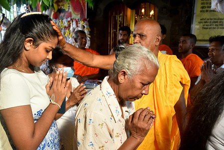 Kotte Rajamahavihara temple chief incumbent anoints the Devotees at the Oil Anointing Ceremony, a tradition of the Sinhala and Tamil New Year at the Kotte Rajamahavihara Temple in Colombo