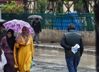 Commuters make their way through a street during rainfall in Srinagar the Summer captial of Indian Administrated Kashmir on April 19, 2023. The weather department has predicted moderate to heavy falls at many places of Jammu and Kashmir for next three days.