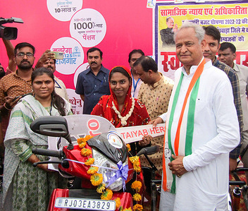 Rajasthan Chief Minister Ashok Gehlot hands over the key of a scooty to a beneficiary during Inflation Relief Camp organised by congress government in Banswara.