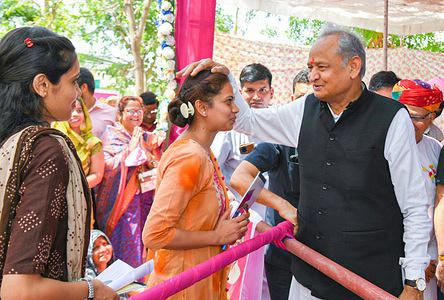 Rajasthan Chief Minister Ashok Gehlot interacts with a benificiary girl during an Inflation Relief Camp, at Nathdwara in Rajsamand district.