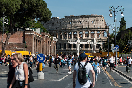 ROME, ITALY - MAY 7: Tourists cross via dei Fori Imperiali in downtown Rome during a sunny day on May 7, 2023 in Rome, Italy.