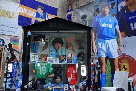 A tour in the historic center of Naples in the neighborhoods of Forcella and Spanish Neighborhoods a few days after the mathematical conquest of Naples of his third Serie A Scudetto thirty-three years after the last of the era of Diego Armando Maradona. Streets full of banners with hymns for the team and many shops selling t-shirts and many other gadgets to remember this historic traquardo of the team of Naples in the Italian Football Championship of Serie A. A crowd of fans and tourists fills the city streets for visit the historical places of Neapolitan typhus.