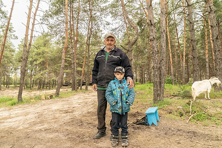 7-years old Artyom and his grandfather Georgy with their goat seen where 92nd tank brigade is getting ready for the front in undisclosed location near village of Kivsharivka of Kharkiv Region of Ukraine. Because of war Artyom is not able to attend school and they are not able for financial reasons to move anywhere from their village.