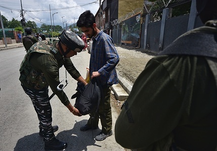 Indian paramilitary troopers search the bag of pedestrian ahead of G20 Summit along a street in Srinagar the Summer captial of Indian Administrated Kashmir on May 18, 2023.