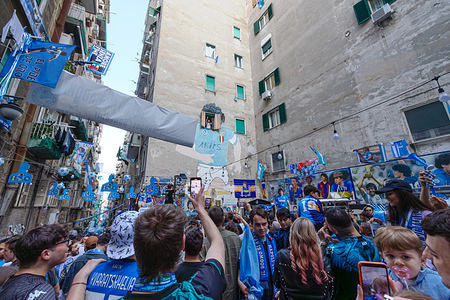 Fans of the Napoli football team celebrate the victory of the Italian championship in the street. Euphoric people flock to the Spanish quarters in front of the Maradona mural.