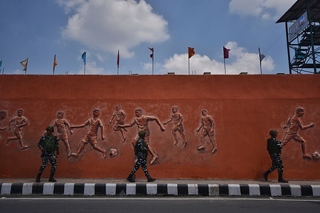 Indian security forces patrol past a wall mural along a street in Srinagar 
 ahead of the G20 meeting to be held on May 22-24, in Srinagar the Summer captial of Indian Administrated Kashmir, on May 20, 2023.