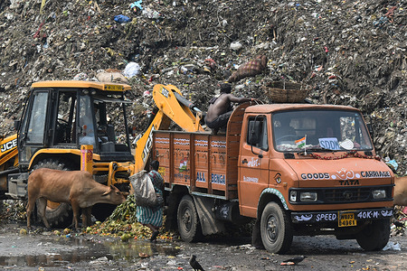 People are working inside a garbage yard on the outskirts of Kolkata.