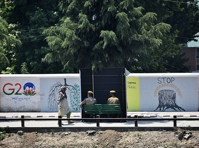 An Indian policeman guards from behind a temporary security post as delegates from the Group of 20 nations arrive to participate in a tourism meeting in Srinagar, Indian controlled Kashmir, Monday, May 22, 2023. The meeting scheduled for later Monday is the first significant international event in Kashmir since New Delhi stripped the Muslim-majority region of semi-autonomy in 2019.