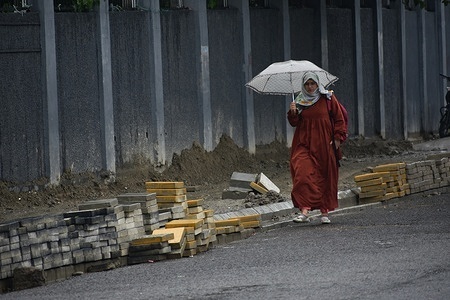 A female Pedestrian walk with holding umbrella as it rains in Srinagar, Kashmir on June 01, 2023. Rains continued across Jammu and Kashmir leading to the drop in temperature, the weather department of Kashmir has predicted further rains in the Valley for the next few days and has adviced farmers across the valley to suspend any work till June 02.