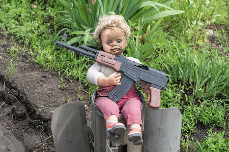 View of a doll with toy rifle on top of the remnants of Russian rocket set by Ukrainian Army Forces on the side of the road in undisclosed location near town of Bahmut Donetsk region.
