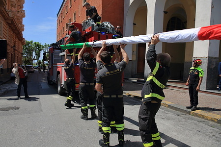 Members of the Fire Brigade of the Provincial Command of Salerno in Piazza Amendola, at work while they arrange the long Italian flag early in the morning on the building of the Offices of the Police Headquarters on the occasion of the celebrations of the "2 June Italian Republic Day".