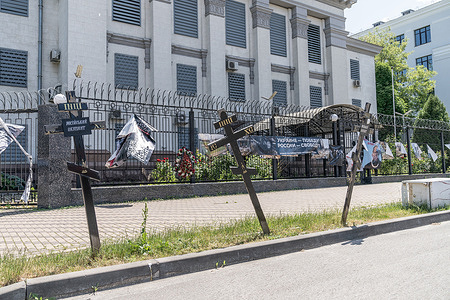 View of Russian Embassy in Kyiv with posters and installations against Russian war with Ukraine. Embassy surrounded by barbed wire and appears to be closed.