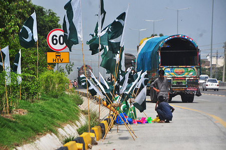 A roadside shopkeeper decorates to attract customers. Preparations for the Independence Day celebrations have started across the country, in this regard, stalls of badges, flags and stickers have been decorated in markets, squares, and different areas.