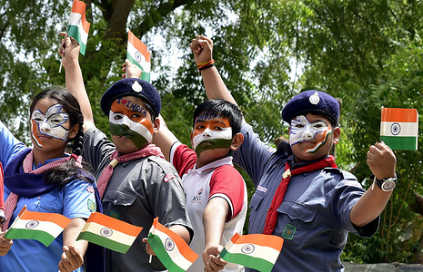 School students with tri-colour painted faces pose for a picture as they prepare for the Independence Day celebrations.