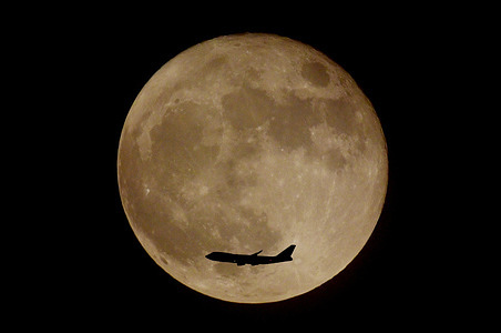 A plane is seen flying over the rare super Blue Moon in Kolkata.