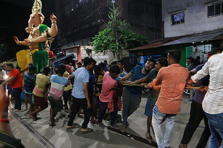 Indian laborers manually transport a 17 foot Hight idol of Hindu goddess Ganesha ahead of the Ganesh Chaturthi festival at Kumartuli or potters' place in Kolkata, India, Friday, Sept. 15, 2023