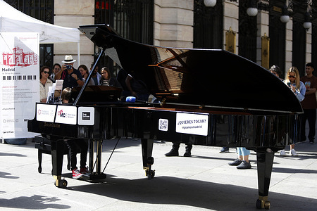 Several professional musicians, music conservatory students, amateurs and the general public are seen playing a grand piano that is placed on a street in Madrid (Spain). A dozen grand pianos (two of them grand grand piano) once again flood the city of Madrid in ten emblematic places in the Las Letras neighborhood, an initiative promoted by the Jesus Serra Foundation and the Maria Canals Competition which is celebrating its 12th edition, transforming the Spanish capital into an open-air auditorium. 'Your city is filled with pianos' ('Tu ciudad se llena de pianos' in Spanish), is being developed for another year thanks to the collaboration of the Madrid City Council and the association of merchants of the Las Letras neighborhood, where Madrid residents and visitors will be able to enjoy a variety of pieces played on the piano. The objective of this initiative is to bring outdoor music and, specifically, the practice of the piano closer to citizens. Similarly, 'Your city is filled with pianos' aims to bring music and pianos closer to society, in addition to discovering talents of the grand instrument, so that they can participate in the Maria Canals International Music Competition (which has celebrated its 68th edition).
