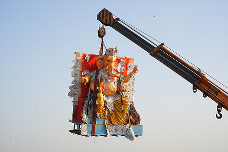 With the help of crane idol of Lord Ganesh immerse to an artificial pond in New Delhi.