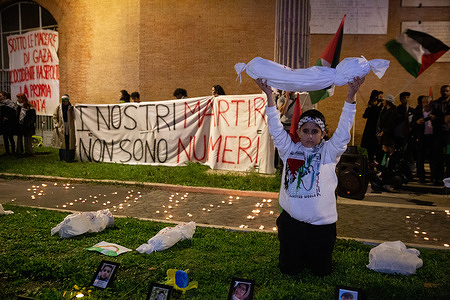 Palestinian children show a sheet symbolizing a Palestinian child killed in Gaza on the lawn in Piazzale Ostiense in Rome