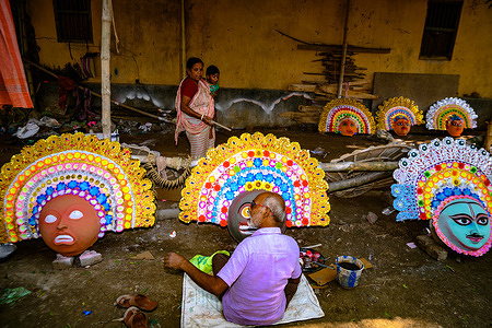 A village idol artist makes large color masks modeled after Purulia Chhau dance masks (Purulia Chhau dance is listed on UNESCO's World Heritage list of dances) of goddesses, animals, and rakshasas (humanoid demons or unrighteous spirits) like Hindu mythology characters out of clay. The artist then paints with color and adorning ornament the clay masks, which will be installed in a Jagaddhatri Puja pandal. Then workers are carrying the finished masks in a car at Tehatta, West Bengal, India on 20/11/2023.