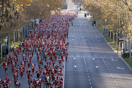 Thousands of people dressed in Santa Claus costumes (for adults) and Elves (for children), including trousers, belt, jacket, hat, and beard, as they take part in the 12th Santa Charity Run on Paseo de Recoletos. The 5-kilometer route through the center of the Spanish capital aims to support the Red Cross and its Vocational Training for Youth at risk of social exclusion project. This project enables many young people to benefit from this training to develop their personal and professional skills with personalized and individualized support. For over 30 years, the Red Cross has provided training, guidance, counseling, and mediation to young people between the ages of 16 and 29 who lack a high school diploma or vocational training. At times, these young people face additional difficulties or risky situations in various areas of their lives: social, family, economic, or emotional. According to information provided by the organizers, more than 7,000 people participated in this year's charity run edition.