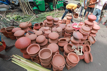 Sri Lankan street vendors arrange sugarcane plants, clay pots and palm leaf decorations for sale ahead of the Thai Pongal Hindu festival in Colombo, Sri Lanka, 14 January 2024.