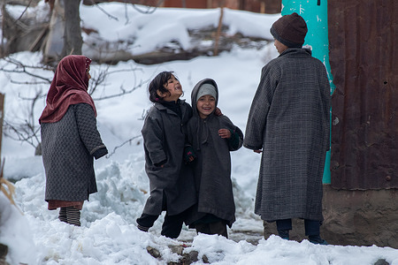 Kashmiri children seen outside their home after heavy snowfall at a village in Budgam district, north-east of Srinagar. Weather across the Kashmir valley has improved after receiving fresh snowfall following prolonged dry weather. Officials said the flight operations at Srinagar Airport and road traffic on the Srinagar-Jammu highway that were hit by the snowfall on Sunday were restored on Monday.