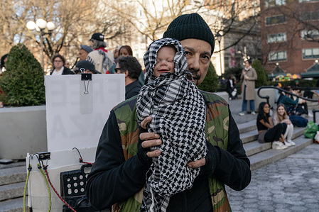 Lone pro-Palestinian activist with doll wrapped in keffiyeh attends American Israeli peace activists rally on Union Square in New York to demand ceasefire in Gaza and hostage release