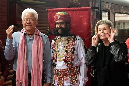 Rajashtani artist with long mustache poses for photos with a tourist after the arrival of Maharajas Express train in Bikaner.