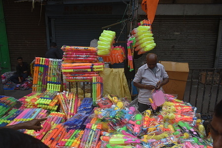 People are selling colors and pichkari from a stall for the Holi festival in Kolkata.