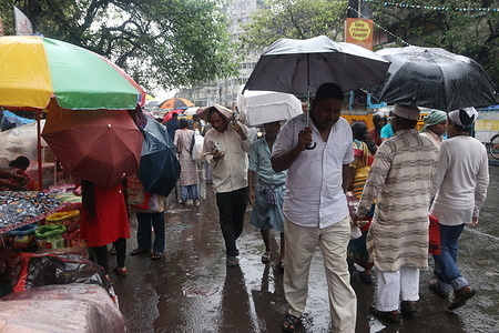 Commuters seen during heavy rainfall in Kolkata.