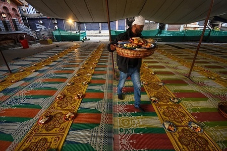 Local mosque members accommodates food for people to break their fast, outside a mosque during holy month of Ramadan. Masjid-e-Bilal (RDA) in Srinagar has become a beacon of generosity, offering Iftar to more than 700 individuals daily during the sacred month of Ramadhan, on March 23,2024 in Srinagar, India.